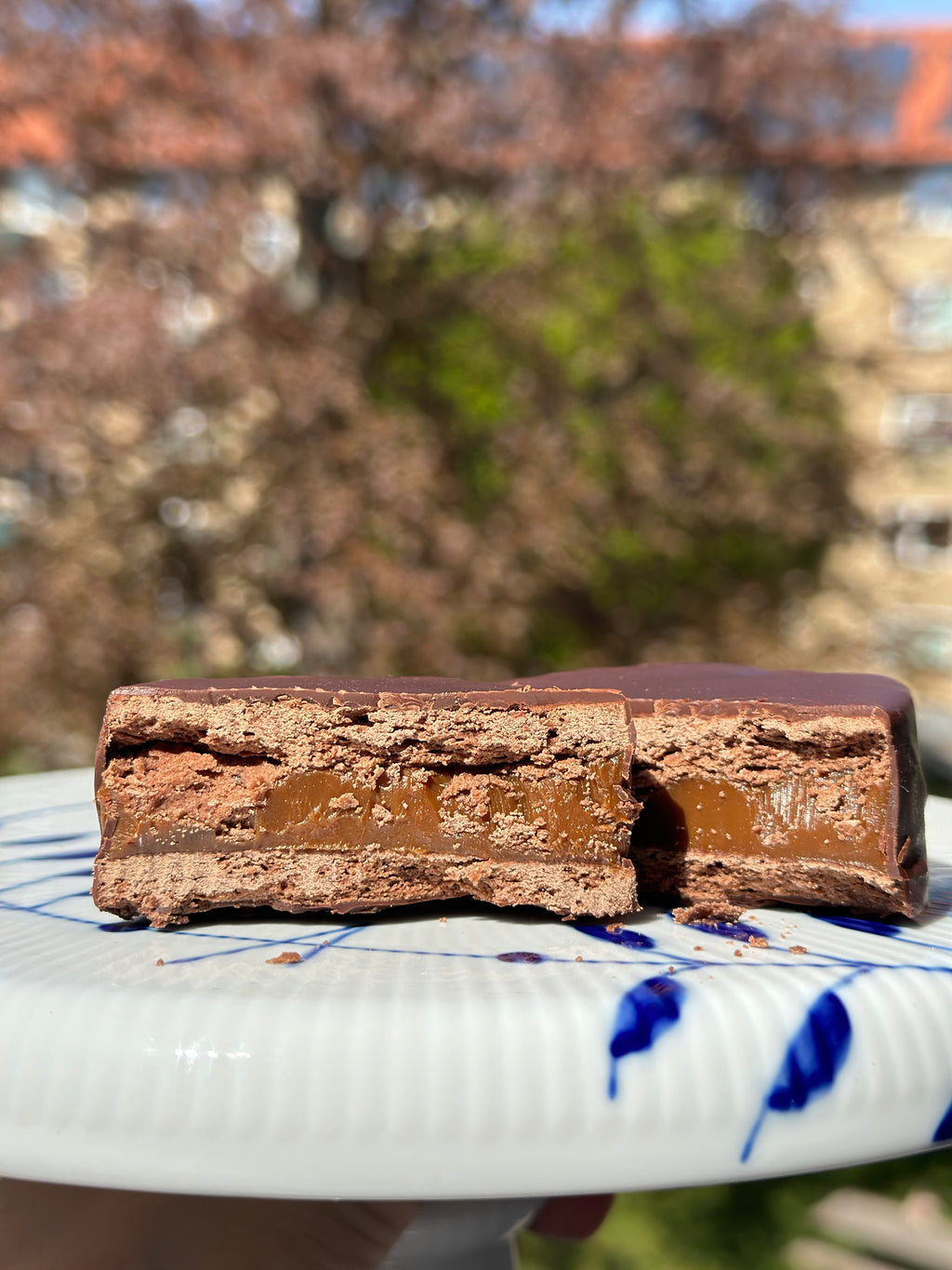 Gluten-free alfajor marplatense cut in half showing dulce de leche filling and chocolate coating, handmade by Gluten Tag in Copenhagen.